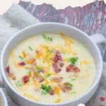 A bowl of creamy baked potato soup topped with shredded cheese, crispy bacon bits, and fresh chives. The text reads "BAKED POTATO SOUP: easy & delicious recipe.