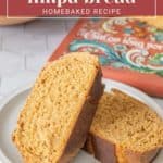 Two slices of aromatic limpa bread rest on a white plate, perfectly complemented by the vibrant hues of a colorful cookbook in the backdrop.