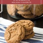 A stack of ginger molasses cookies rests on a striped cloth with more cookies in a jar in the background. The text header reads, "Ginger Molasses Cookies: Holiday Favorite.