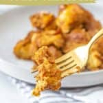 Close-up of a fork holding a bite of golden-brown pumpkin French toast casserole. Text over image reads, "slow cooker pumpkin french toast casserole made in the slow cooker - www.stetted.com.