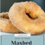 Close-up of two potato donuts with a golden-brown crust on a blurred background. Text overlay reads "How to Make Mashed Potato Donuts.