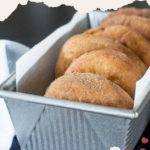 Close-up of mashed potato donuts in a metal tray lined with parchment paper, showcasing a simple and delicious potato donuts recipe that's sure to delight your taste buds.