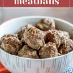 A bowl of baked bison meatballs is placed on a table.