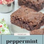 Close-up of three fudgy peppermint brownies on a light-colored surface. A small bowl of chopped peppermints and a holiday-themed napkin add festive flair. Text reads, "Fudgy Peppermint Brownies.