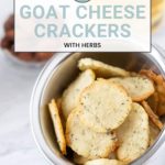 A bowl of herb-infused goat cheese crackers rests beside a glass of golden delight.