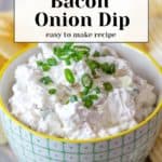 A savory bacon onion dip topped with fresh green onions sits invitingly in a bowl, while a plate of crispy potato chips waits enticingly in the background.