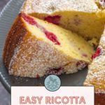 Ricotta cake with raspberries, elegantly dusted with powdered sugar, is sliced and served on a chic gray plate.