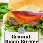 Savor our ground bison burger with fresh lettuce, juicy tomato, melted cheese, and red onion on a fluffy bun. Paired perfectly with green beans. Text reads "Ground Bison Burgers: easy & delicious.