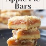 Three apple pie bars, stacked on a black plate, showcase their crumbly tops and luscious apple filling. The text above reads "Easy Fall Treat: Apple Pie Bars.