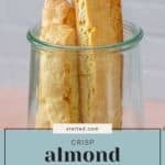 A glass jar filled with several tall, crisp almond biscotti. Text overlay reads "stetted.com Almond Biscotti.