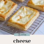 A close-up of freshly baked cheese danish pastries cooling on a wire rack. The text "EASY HOMEMADE RECIPE" is printed on a white background below the image, highlighting the delicious cheese danish treats.