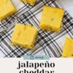 Six pieces of jalapeño cornbread placed on a black and white checkered cloth with text that reads "jalapeño cheddar cornbread" and "perfect soup pairing.