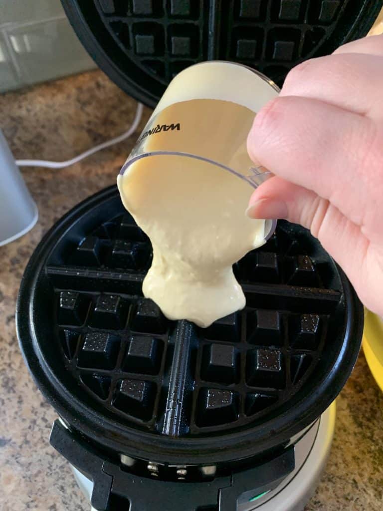 pouring buttermilk waffle batter into waffle iron