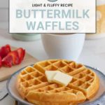 A plate featuring delicious buttermilk waffles topped with butter, strawberries on the side, and a cup nearby invites you to try this irresistible waffle recipe.