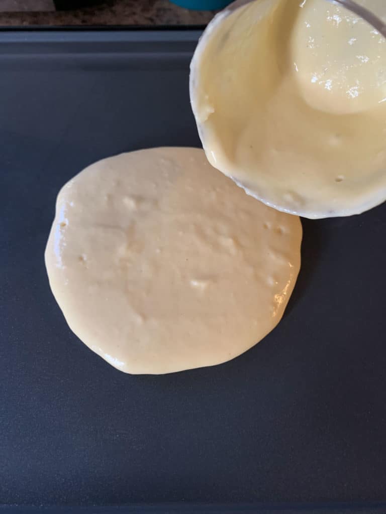 pouring pancake batter onto griddle