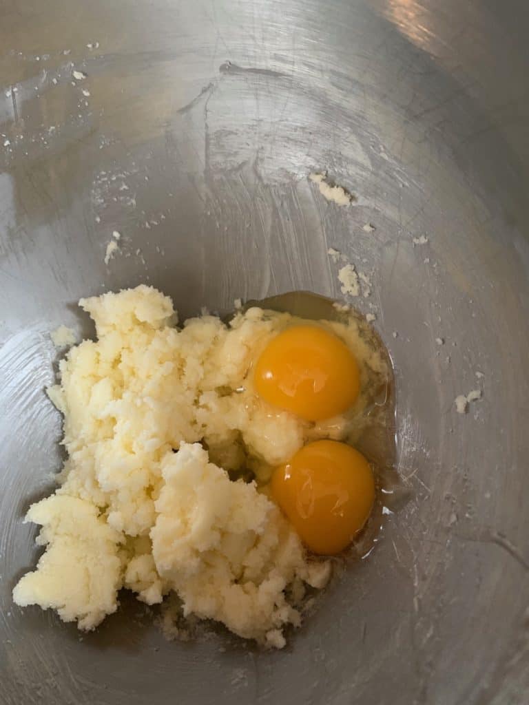 adding eggs to butter and sugar