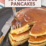 Close-up of a fork cutting into a stack of delicious applesauce pancakes on a plate, featuring text overlay promoting an easy breakfast recipe.