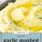 A bowl of creamy garlic mashed potatoes topped with melted butter and garnished with parsley, alongside text reading "CREAMY garlic mashed potatoes" from stetted.com.