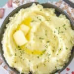 A bowl of garlic mashed potatoes garnished with butter and parsley. Text reads "Garlic Mashed Potatoes" at the top, with "stetted.com" at the bottom.