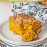 A slice of pumpkin coffee cake with crumb topping on a plate, accompanied by a fork. The background has a patterned cloth and part of a baking dish. Text: "Pumpkin Coffee Cake" - an autumn breakfast treat.