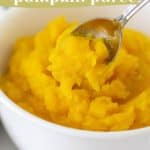 Close-up of a white bowl filled with creamy pumpkin puree. A spoon is scooping some of the puree. Text overlay reads, "homemade pumpkin puree - fall baking essential.