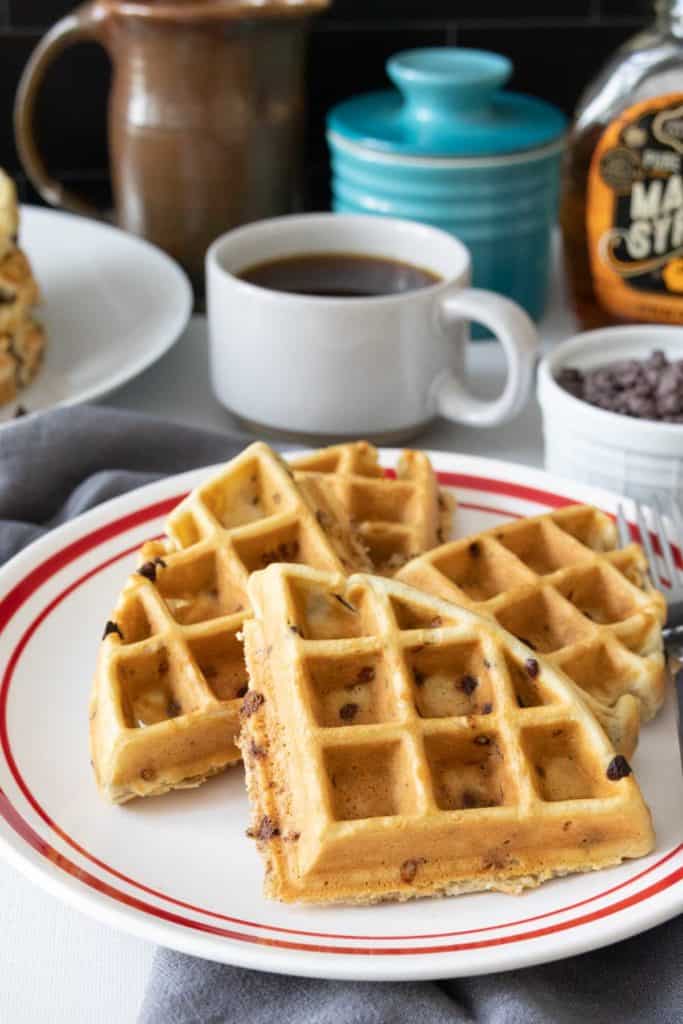 Plate of chocolate chip waffles cut into quarters.