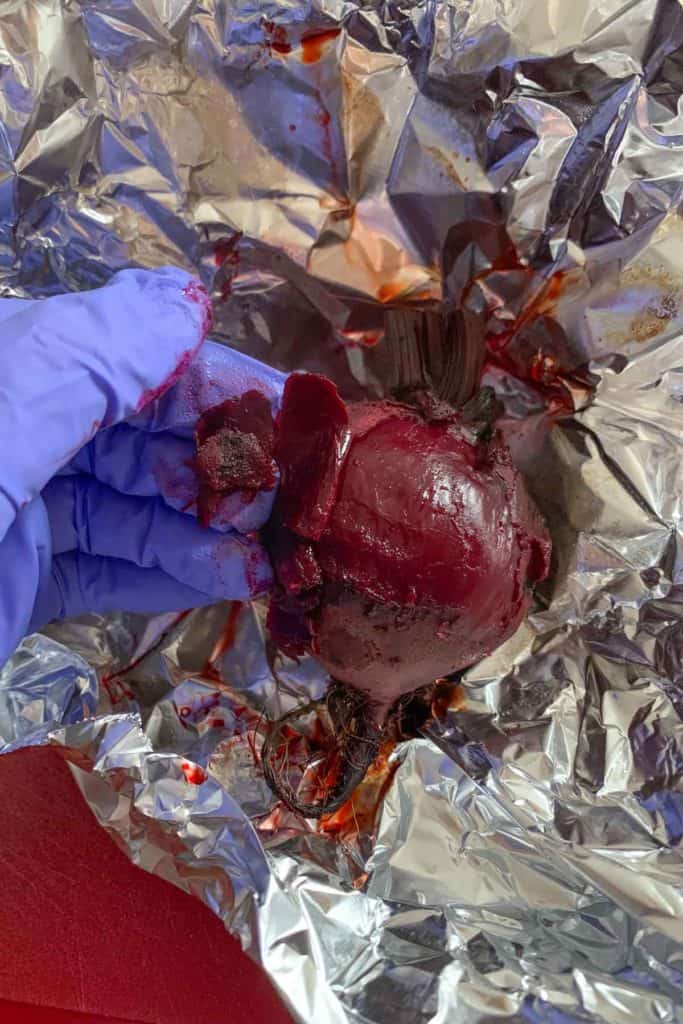 Peeling beets while wearing gloves.