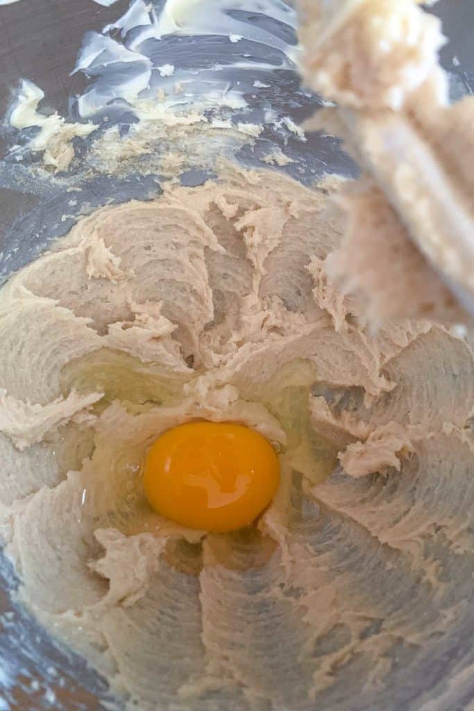 Adding egg to muffin batter.