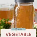 A mason jar brimming with fresh homemade vegetable stock sits on a table, surrounded by fragrant herbs and a measuring cup. Text reads: "Simple Homemade Vegetable Stock Recipe.