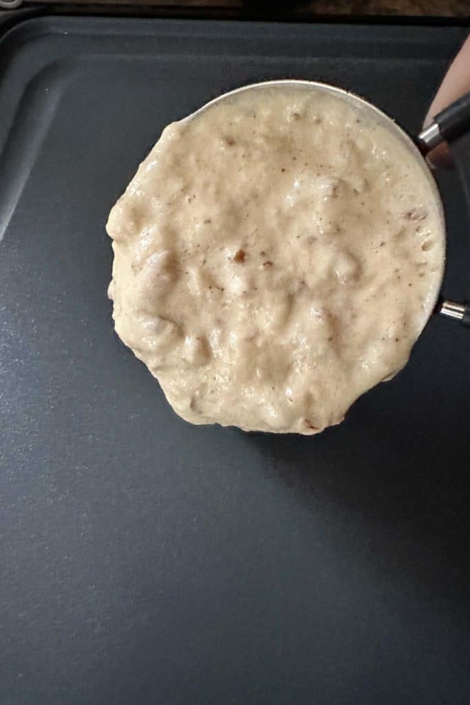 Pouring pecan pancake batter onto an electric griddle.