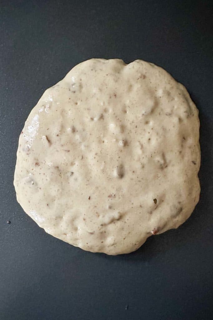 Cooking a pecan pancake on an electric griddle.