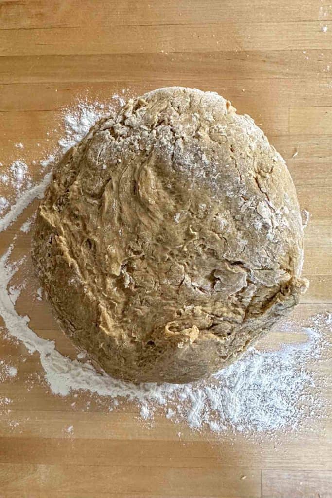 Limpa dough on wooden kitchen island before kneading.