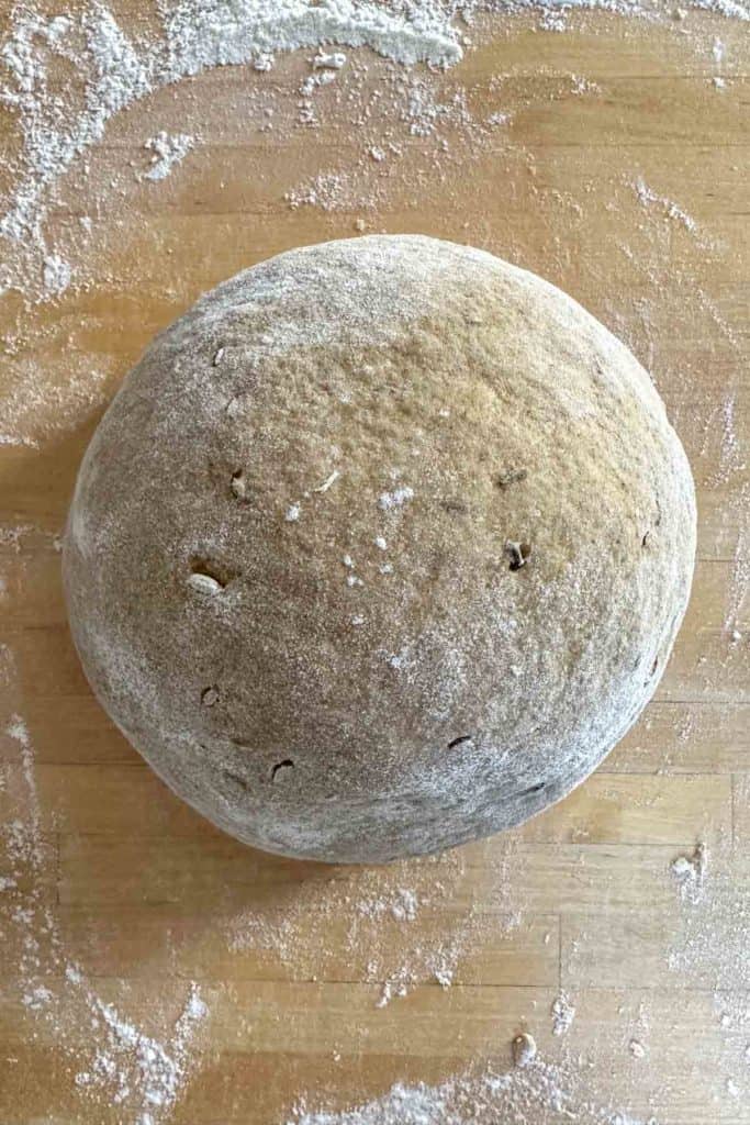 Kneaded ball of limpa bread dough on wooden island.