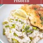 A plate of creamy asparagus risotto is perfectly paired with a lemon wedge and a piece of grilled chicken on a white plate.