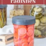 A jar of pickled radishes with sliced rounds and mustard seeds sits invitingly on a kitchen counter, surrounded by other jars and a crisp white towel.