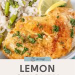 A plate of zesty lemon chicken garnished with fresh parsley, accompanied by flavorful rice mixed with asparagus, with vibrant lemon slices on the side.