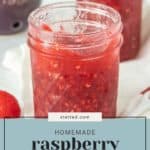 Close-up of a jar filled with homemade raspberry jam, with a second jar in the background. Raspberries and a bowl are visible behind the jars. The text overlay reads, "Homemade Raspberry Jam Recipe - stetted.com.