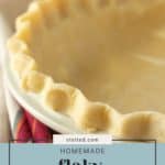 A close-up of an unbaked homemade pie crust in a white pie dish. The crust has a crimped edge, and a colorful towel is partially visible underneath. Text reads "stetted.com Homemade flaky pie crust.