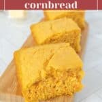 Four slices of tender sweet potato cornbread are arranged on a wooden board, showcasing their moist, dense texture. In the blurred background, various food items and a butter dish can be seen. Text on image: "Tender sweet potato cornbread.