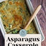 A delightful asparagus casserole, baked to perfection with a crunchy breadcrumb topping, rests in a rectangular dish. Served with a wooden spoon on a rustic wooden surface, this easy and delicious dish is pure comfort food.