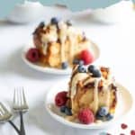 Two plates of delectable croissant bread pudding are topped with fresh berries and drizzled with a luscious sauce. Two forks rest beside the plates, ready for indulgence. Text at the top reads "croissant bread pudding.