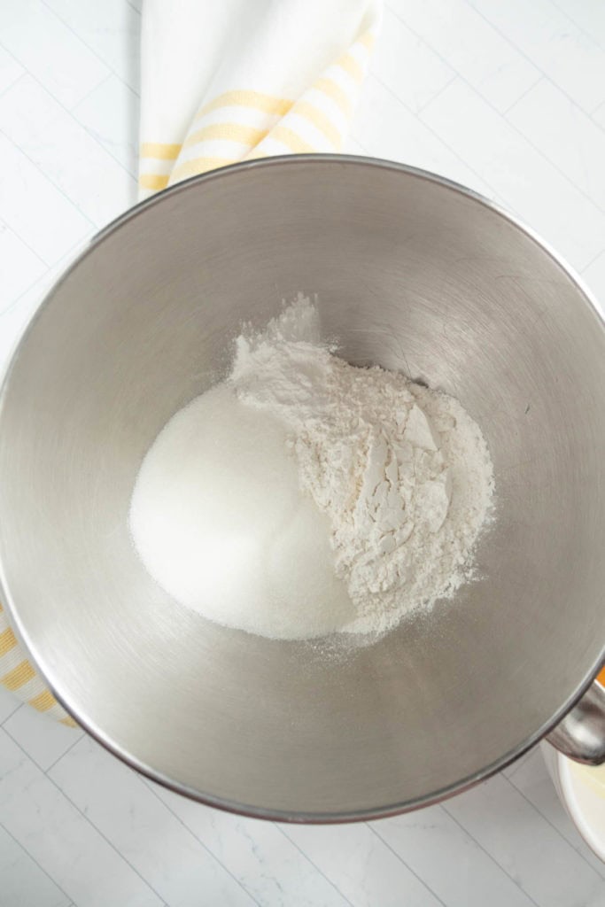 A mixing bowl contains a mixture of sugar and flour.