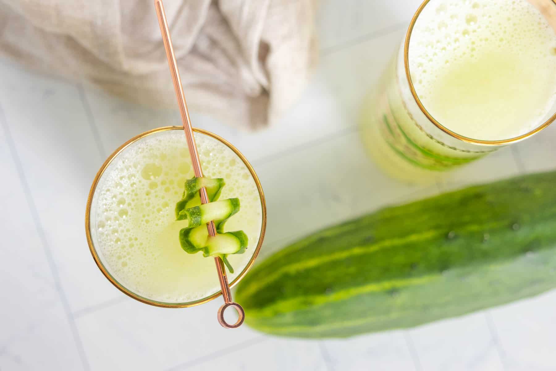 Two glasses of cucumber agua fresca from overhead.