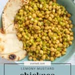 A green bowl filled with mustard chickpea salad mixed with diced vegetables, served with slices of flatbread. A napkin and part of a white background are visible. Text reads "Lemony Mustard Chickpea Salad".