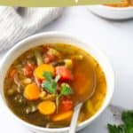 A bowl of instant pot vegetable soup with carrots, beans, tomatoes, and greens is garnished with fresh parsley. Text overlay reads, "Easy vegetable soup made in the Instant Pot!" with a website URL at the bottom.