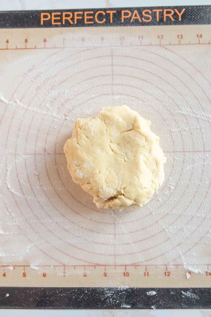 A ball of dough rests on a pastry mat labeled "Perfect Pastry" with measurements and guides for rolling out dough.