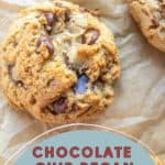 Close-up of chocolate chip pecan cookies on brown parchment paper. The cookies are golden brown with visible chocolate chips and pecan pieces.