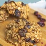 Close-up of cranberry breakfast cookies made with oats and dried cranberries, displayed on a wooden surface. Text on the image reads "cranberry breakfast cookies" and "stetted.com".