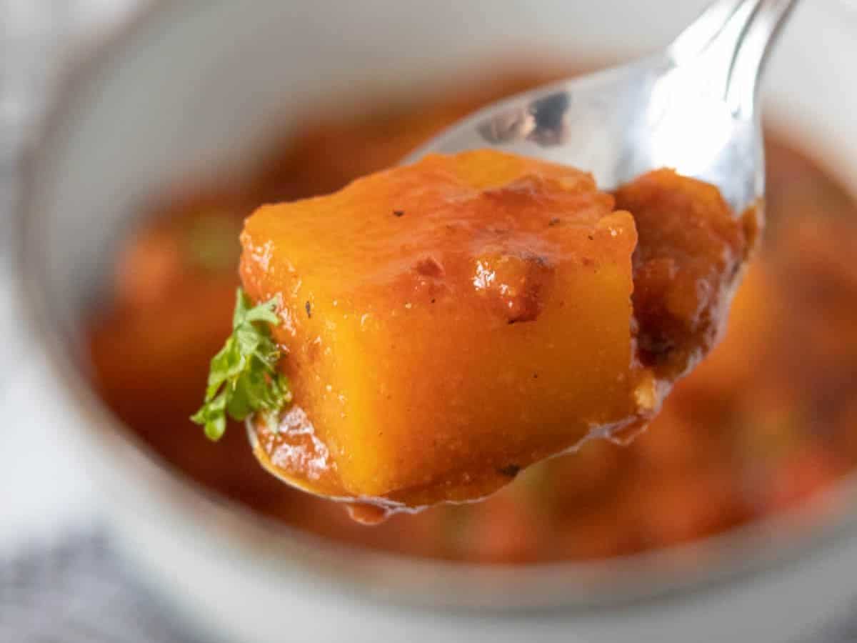 Close up of a butternut squash cube on a spoon.