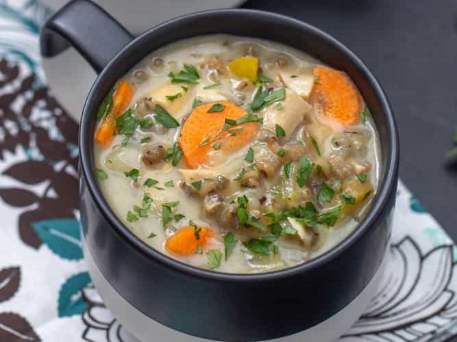 chicken wild rice soup in black and white mugs with a floral napkin